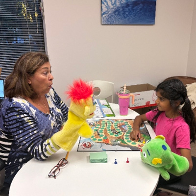 Mara H. Lane, M.S., CCC/SLP with young client.